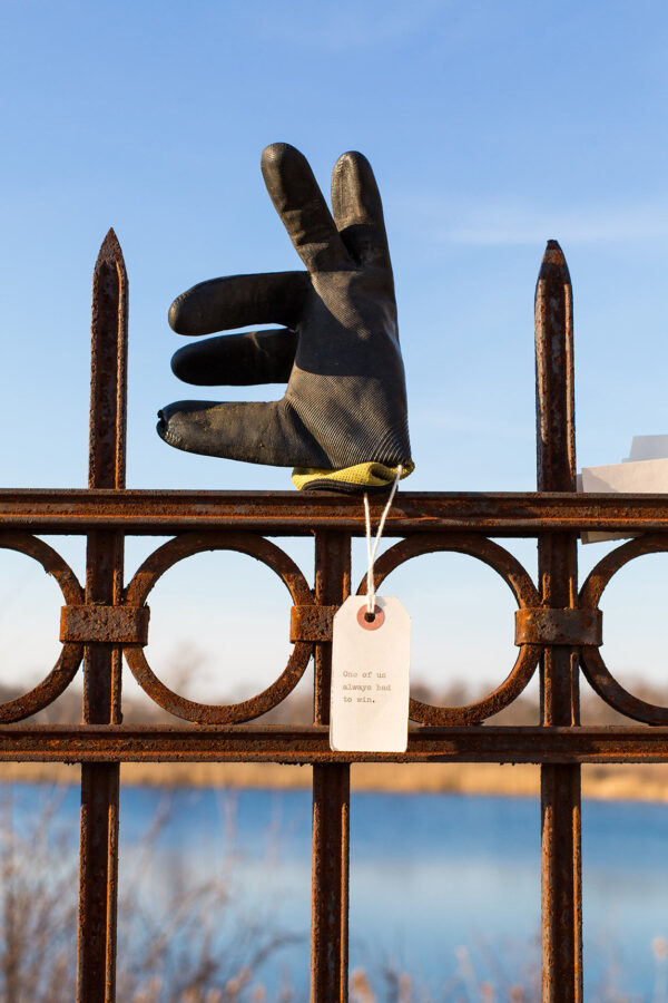 A found glove with a note displayed on a wrought iron fence in the Library of Lost Gloves & Lost Loves participatory public art installation by artist Bruce Willen