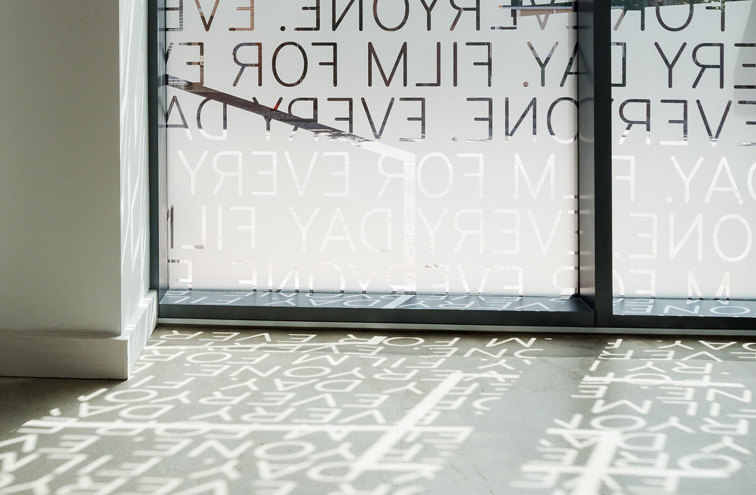 Light filters through the windows of the Parkway, casting shadows of typography on the floor