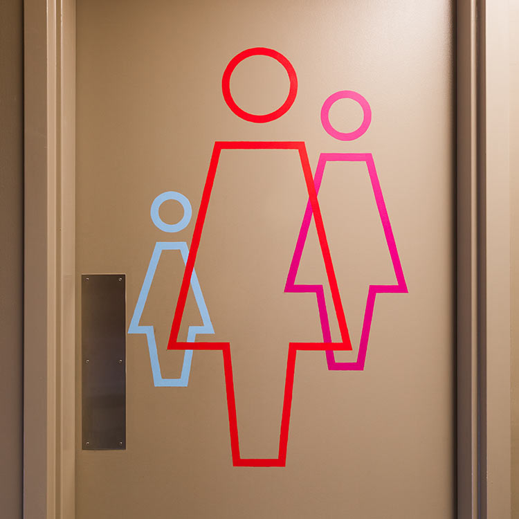 Branded restroom signage and wayfinding supergraphics at the Parkway Theatre in Baltimore