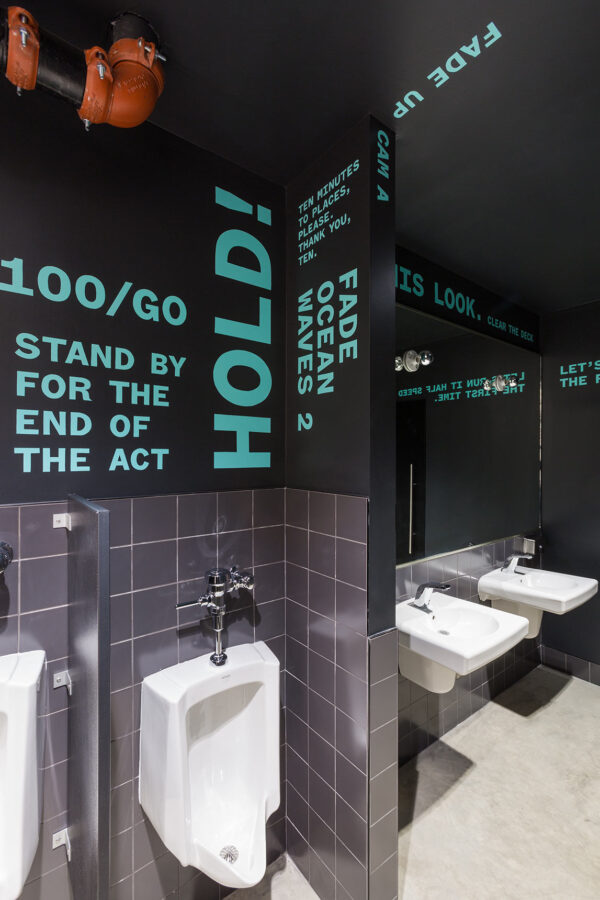 Mint-colored giant typography kinetic poetry wraps around the restroom interiors of the Voxel Theater