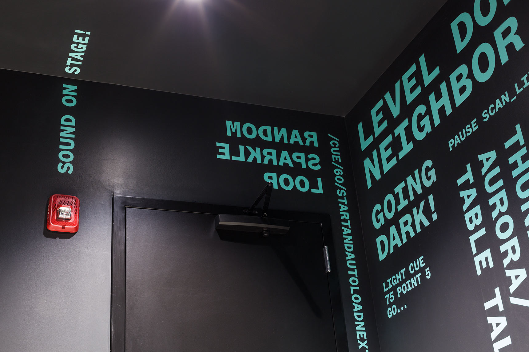 Mint-colored giant typography kinetic poetry wraps around the restroom interiors of the Voxel Theater